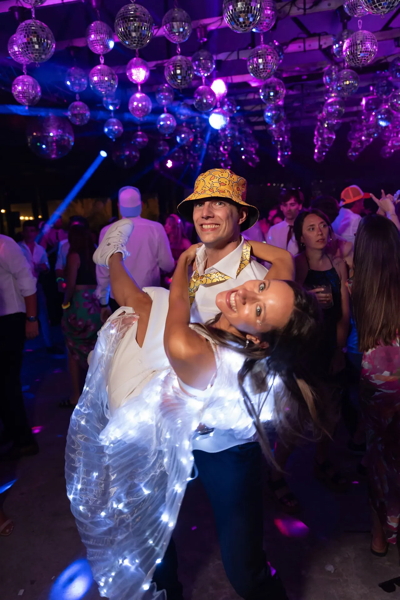 Pareja bailando bajo bolas de espejo en una fiesta de boda