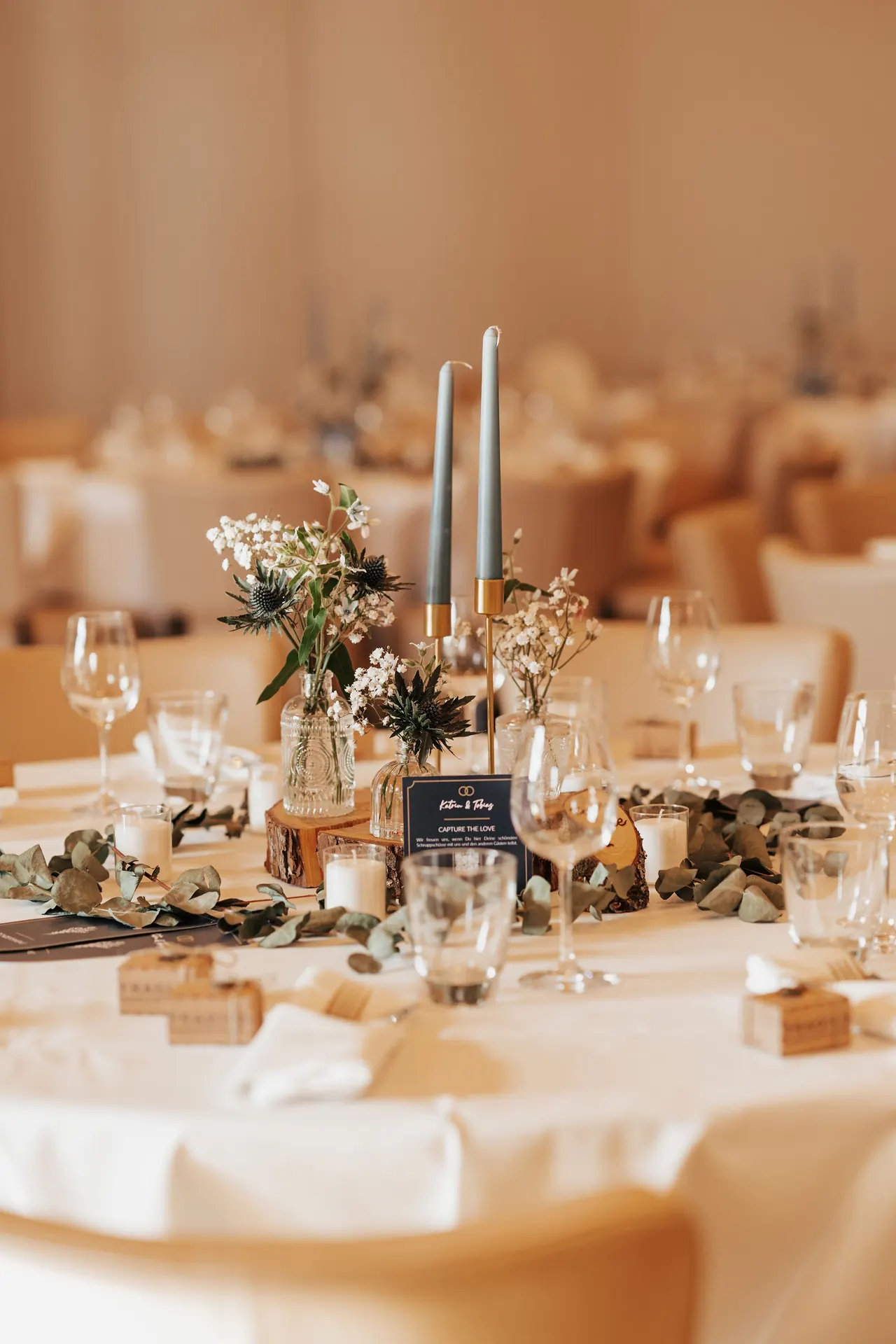Mesa de recepción con velas, cristalería y centros florales