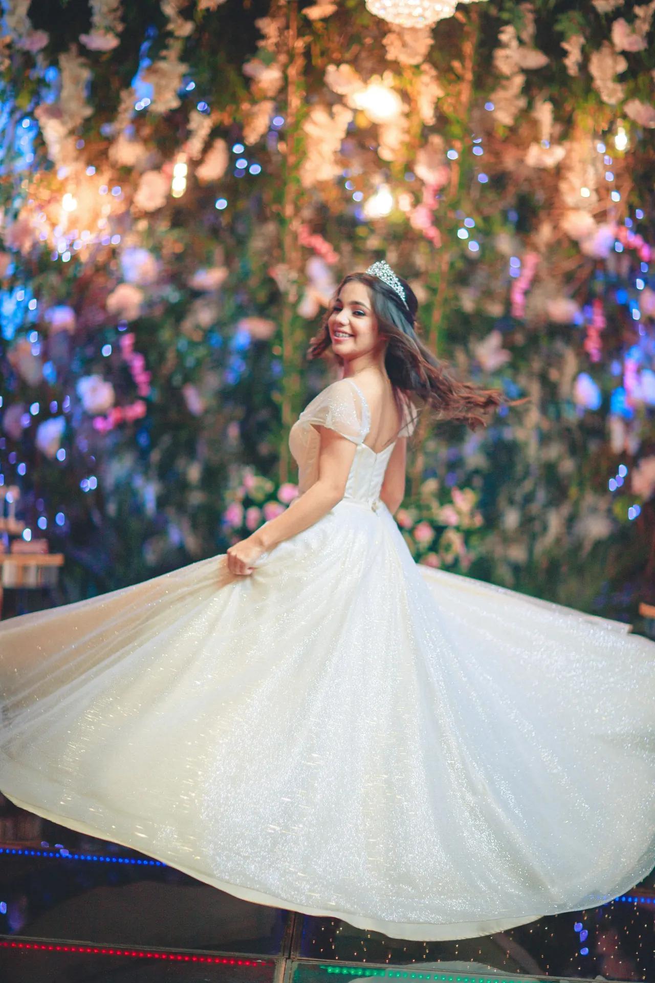 Novia girando con su vestido bajo luces nocturnas