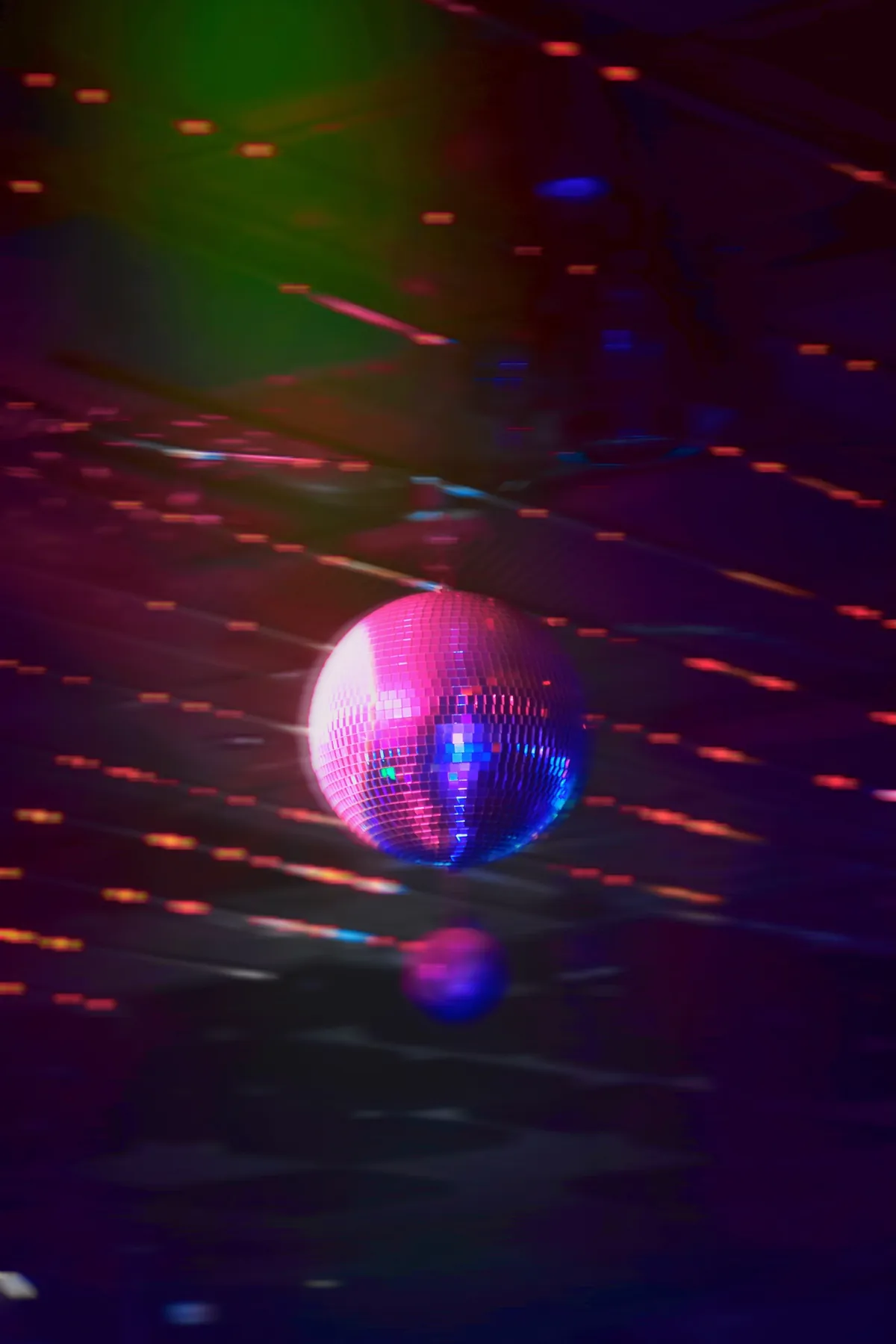 Bola de espejos de una discoteca reflejando luces rosas y azules